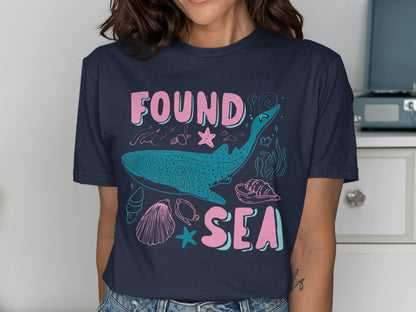 Dark blue t-shirt with whale, shells, and "FOUND SEA" text.