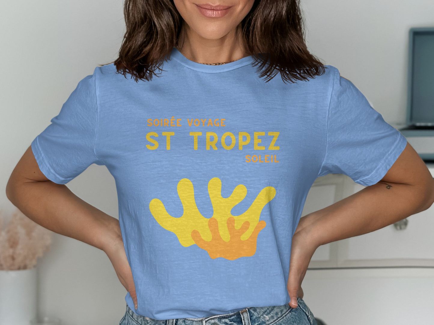Light blue t-shirt with yellow "ST TROPEZ SOLEIL" text and coral graphic.