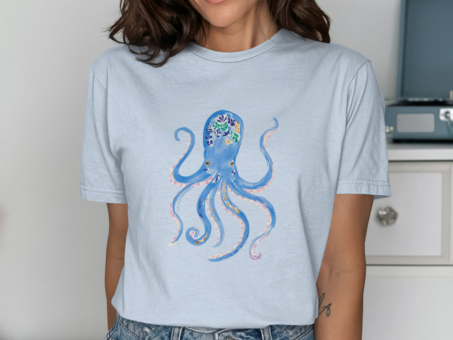 Light blue t-shirt featuring a watercolor-style blue octopus with colorful floral accents.
