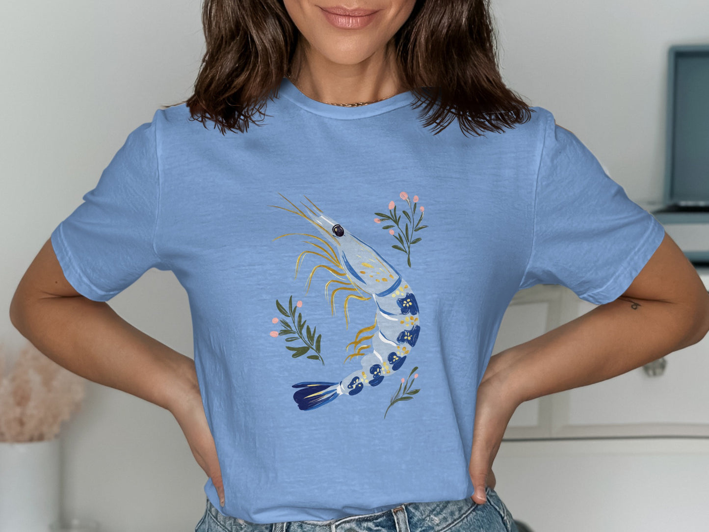 Blue t-shirt with a detailed illustration of a blue and white shrimp with pink flowers.