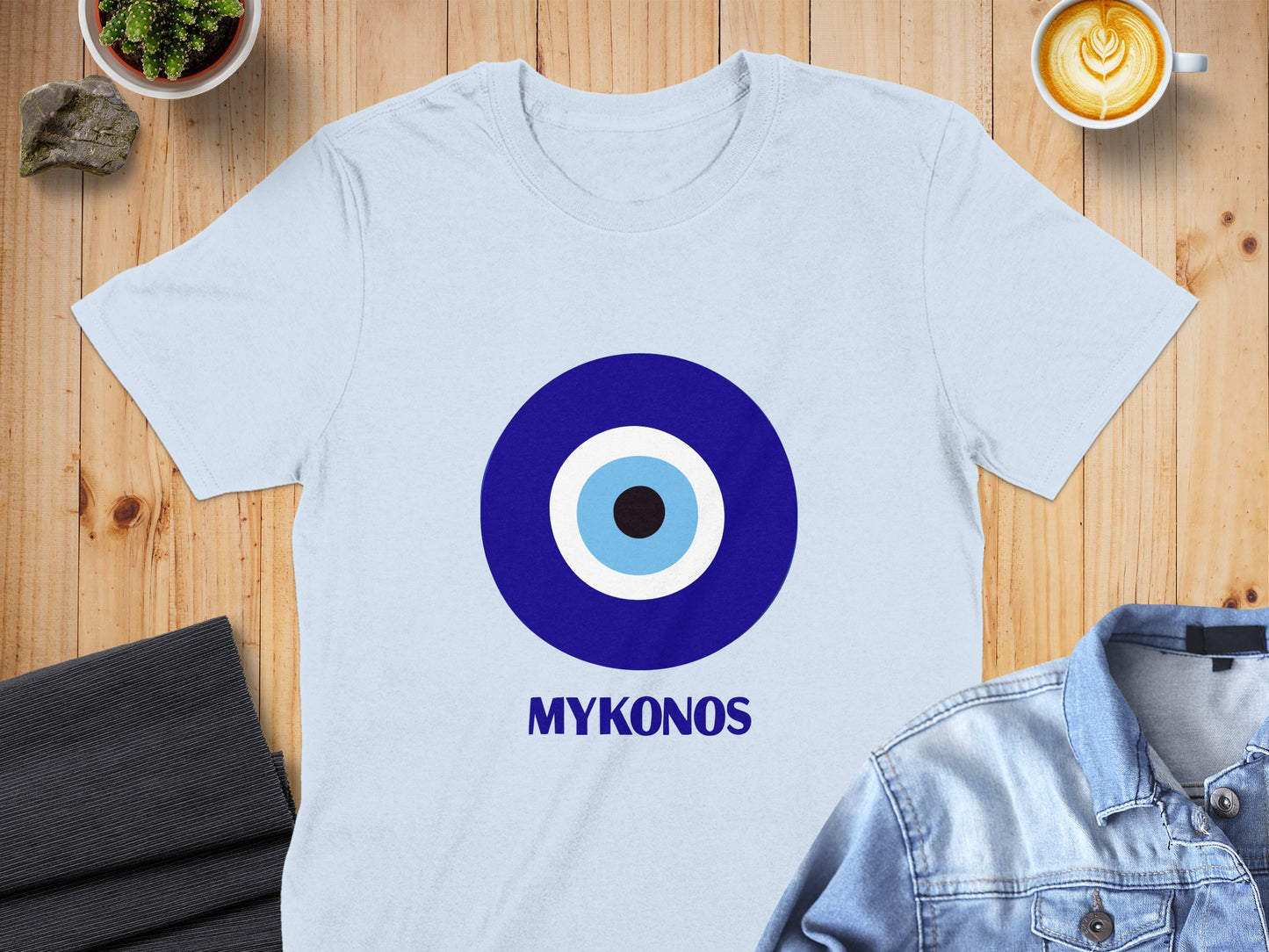 Light blue t-shirt with a large blue and white evil eye symbol and "MYKONOS" text.