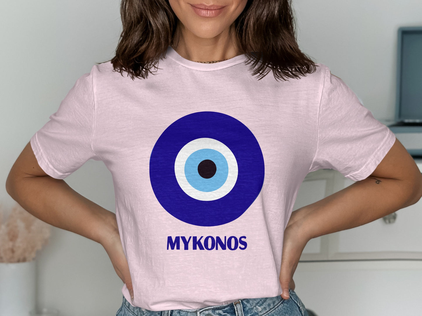 Pink t-shirt with a blue evil eye design and "MYKONOS" text.