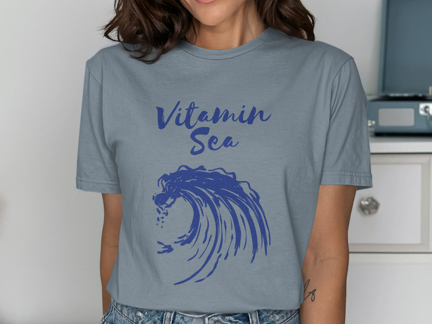 Blue t-shirt with "Vitamin Sea" and crashing wave graphic.