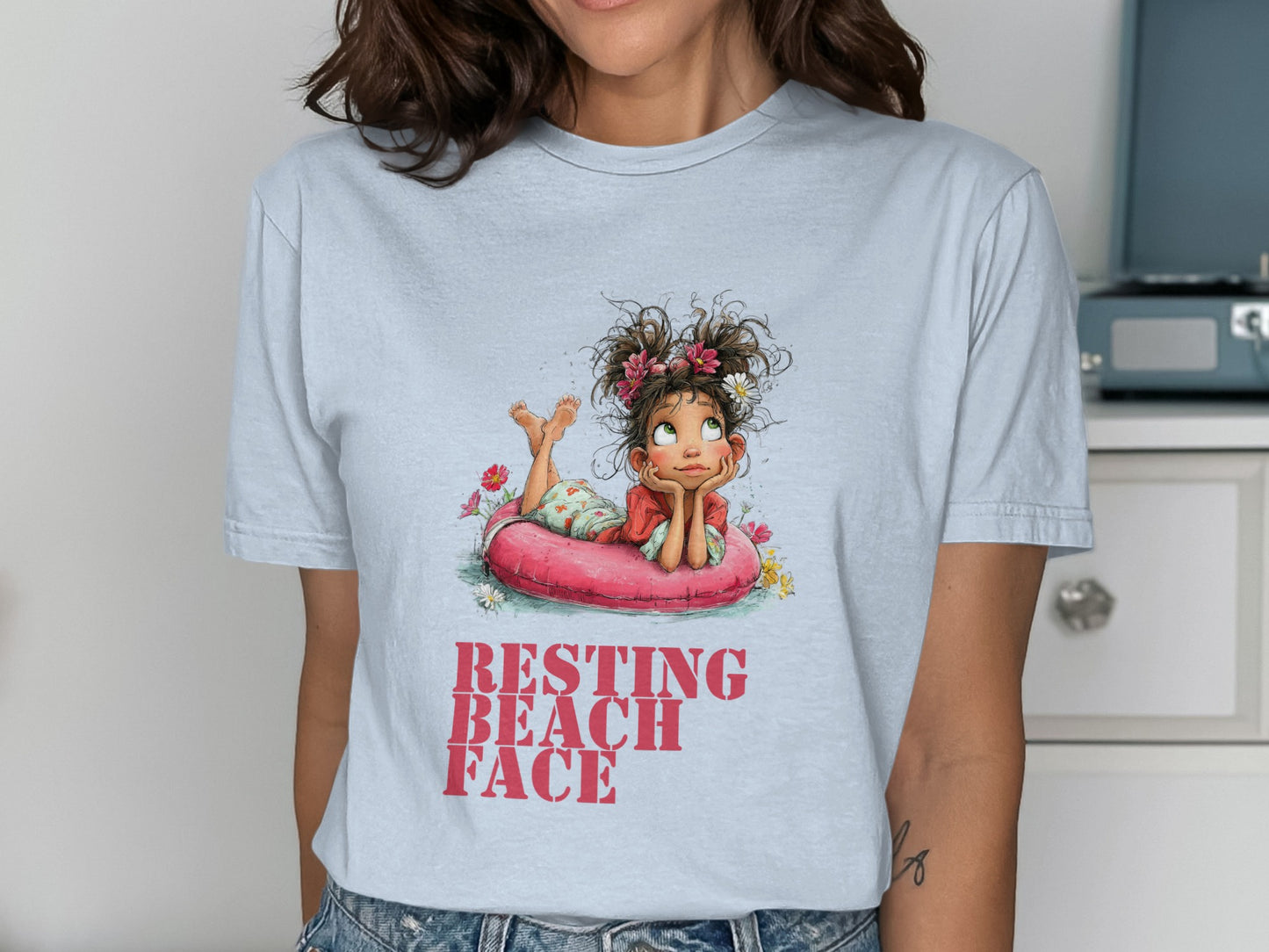 T-shirt graphic of a girl in a float with text "RESTING BEACH FACE".