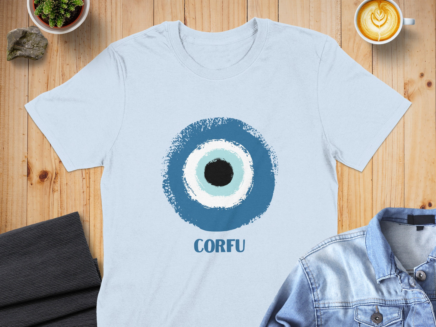 Light blue t-shirt with a blue and white evil eye design and "CORFU" text.