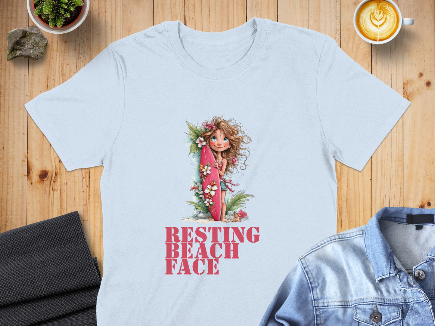 Light blue t-shirt with "RESTING BEACH FACE" text and girl with surfboard graphic.