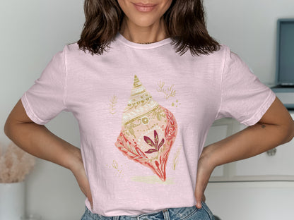 Pink t-shirt with a detailed illustration of a large seashell.