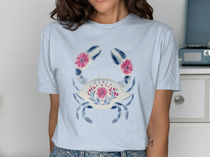 Light blue t-shirt with a stylized crab design featuring floral accents.