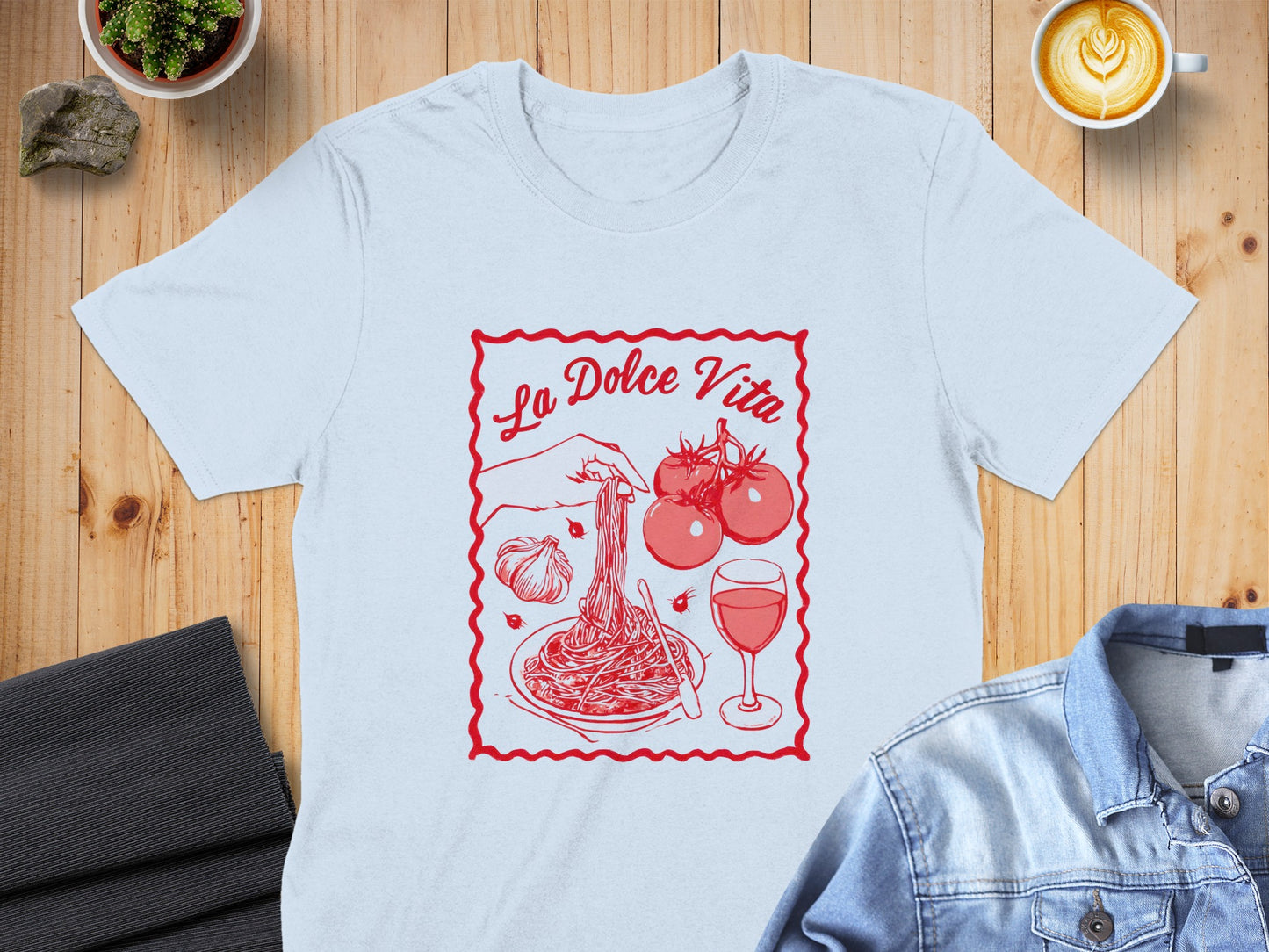 Light blue t-shirt with "La Dolce Vita" text and pasta, tomatoes, and wine illustration.