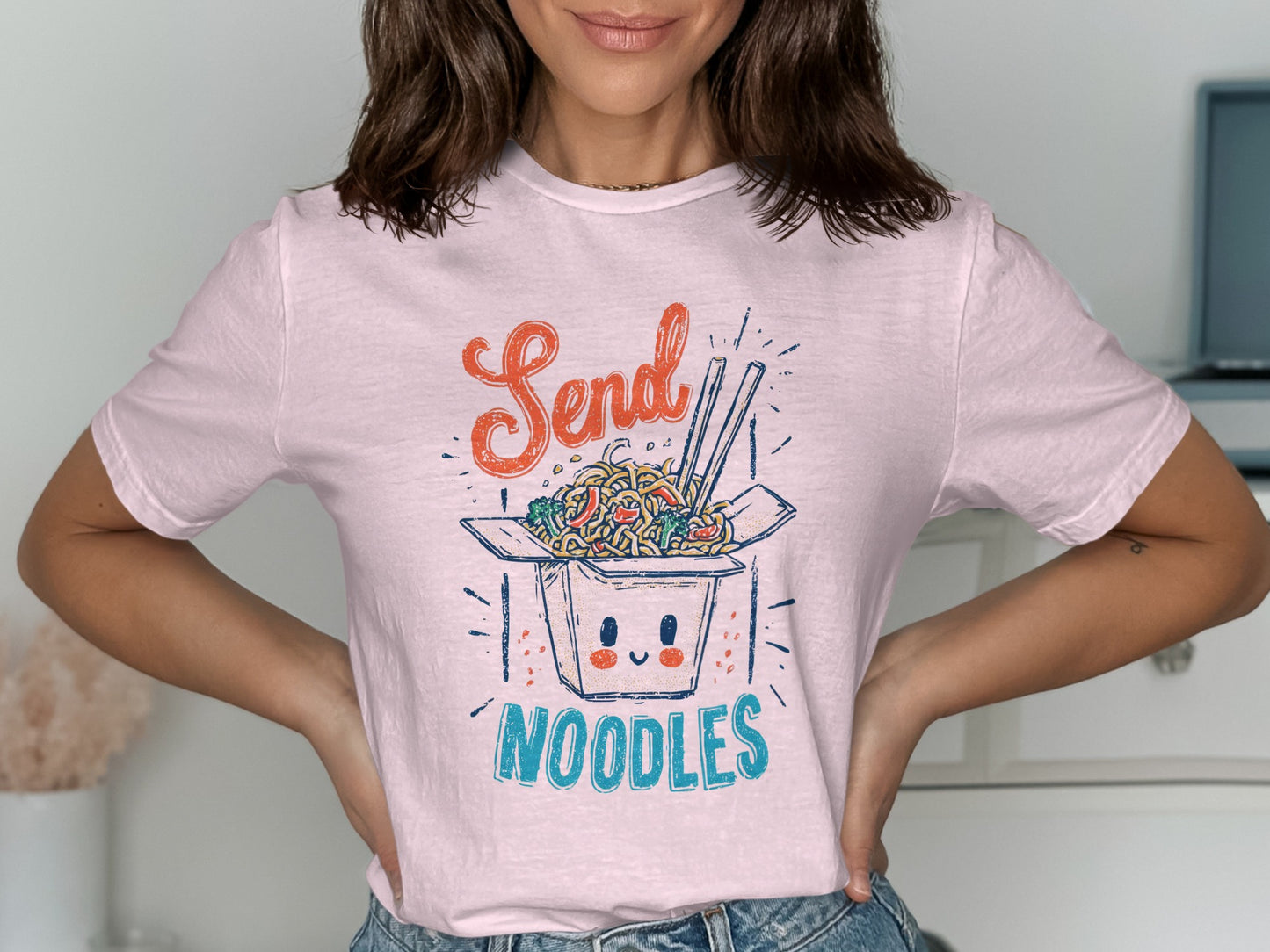 Pink t-shirt with "Send Noodles" text and a cartoon noodle box illustration.