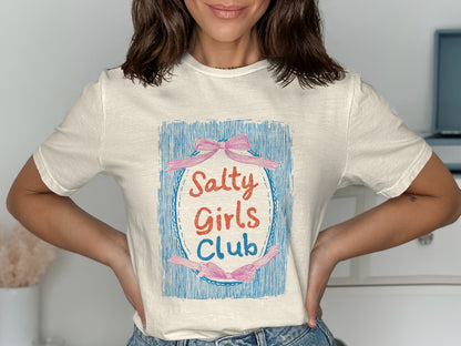 Cream t-shirt with "Salty Girls Club" text and pink ribbon graphic.