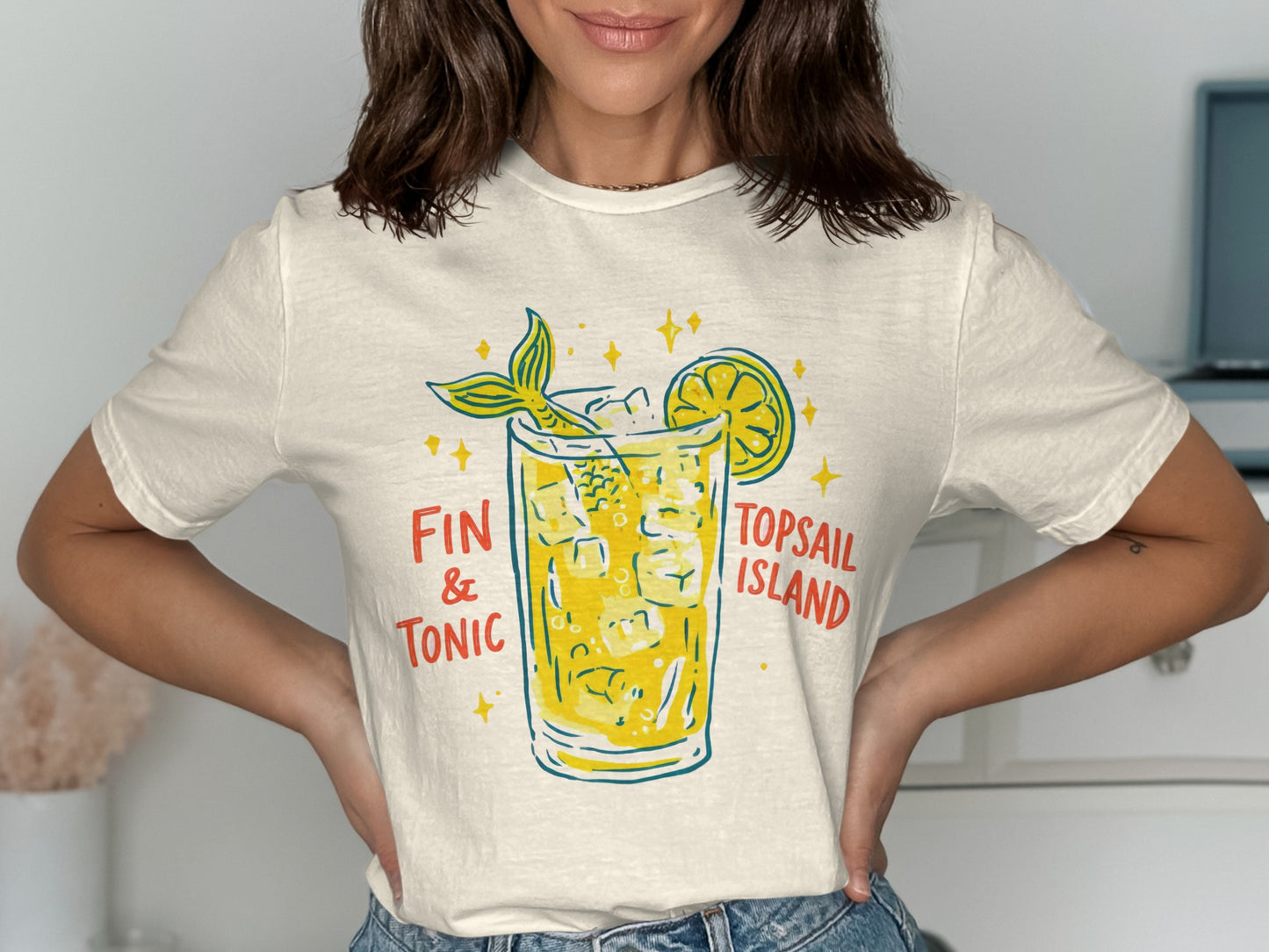 Cream t-shirt with graphic of a Fin & Tonic cocktail and lemon slice.