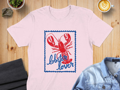 Pink t-shirt with a blue bordered stamp graphic of a red lobster and the text "lobster lover".