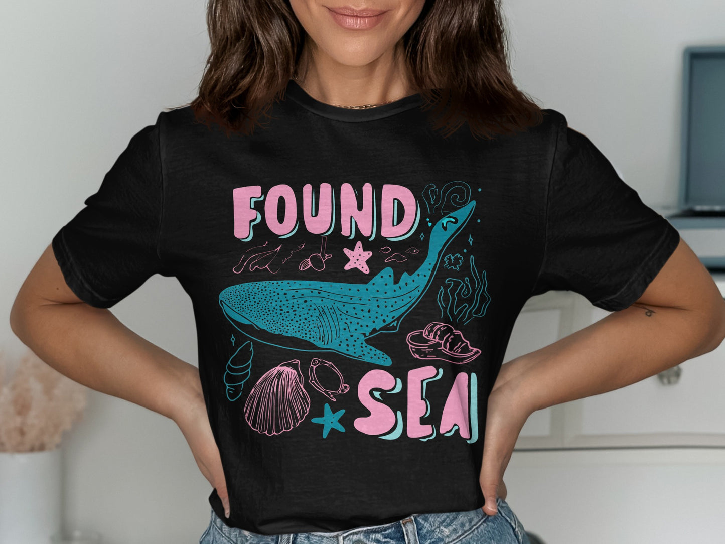 Black t-shirt with "FOUND SEA" text and marine life graphics.
