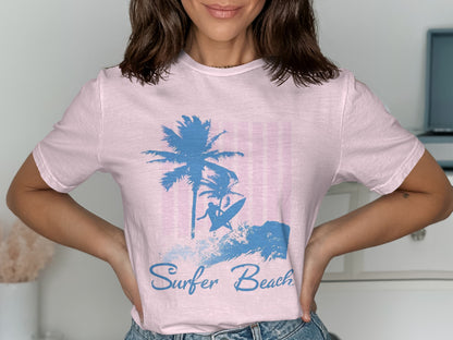 Pink t-shirt with blue surfer and palm tree graphic and text "Surfer Beach."