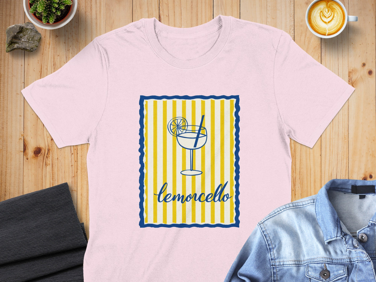 Pink t-shirt with a limoncello glass graphic and blue and yellow striped border.