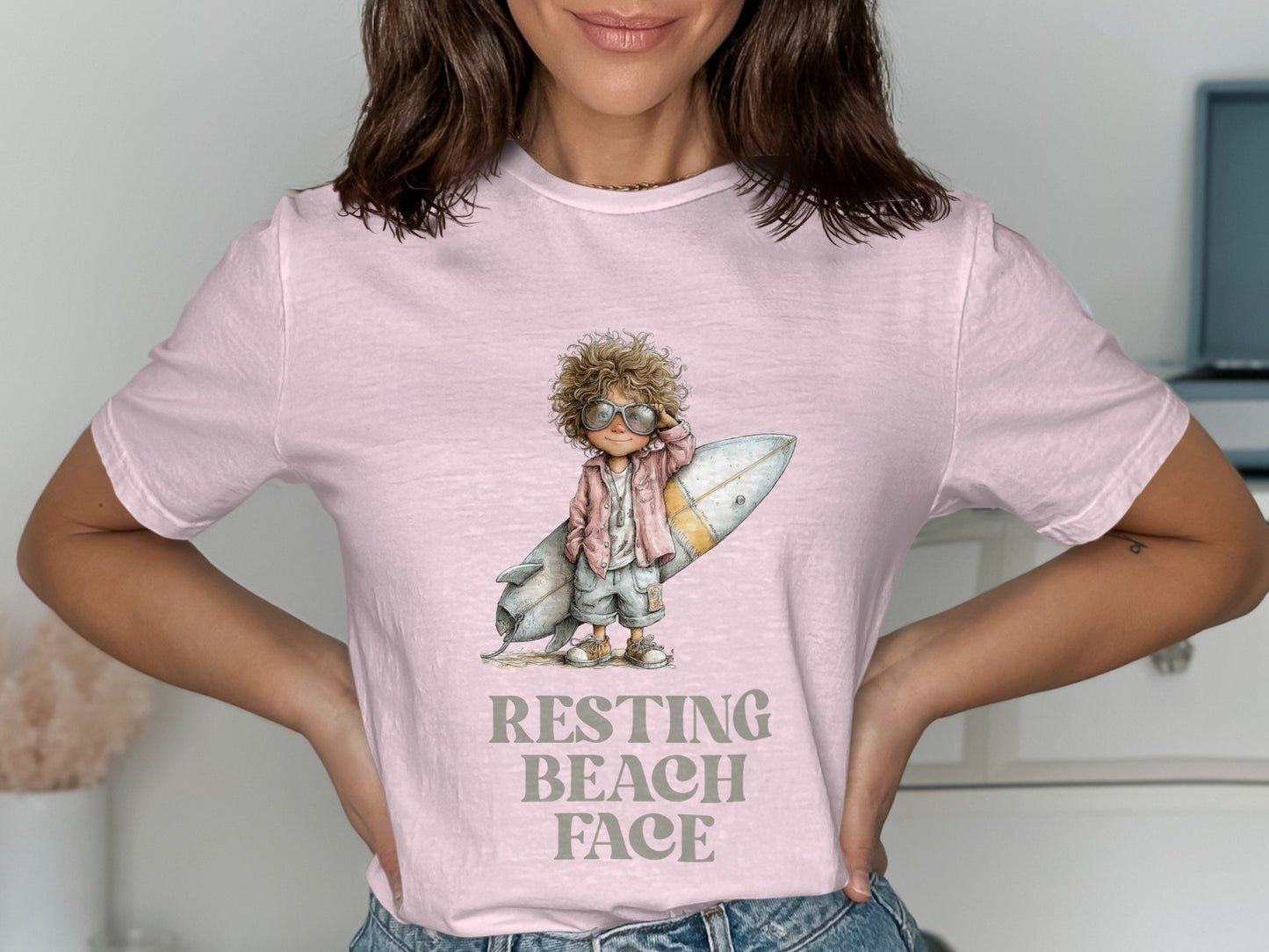 Girl with sunglasses and surfboard, "Resting Beach Face" text on pink t-shirt.