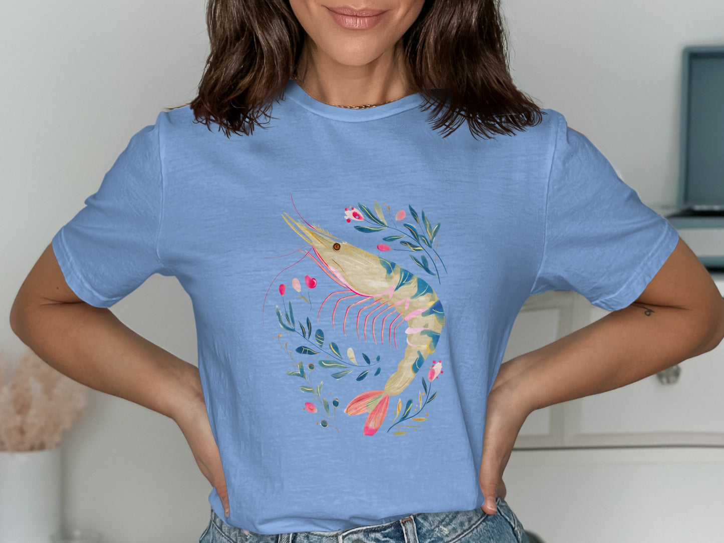 Blue t-shirt featuring a watercolor shrimp illustration with floral accents.