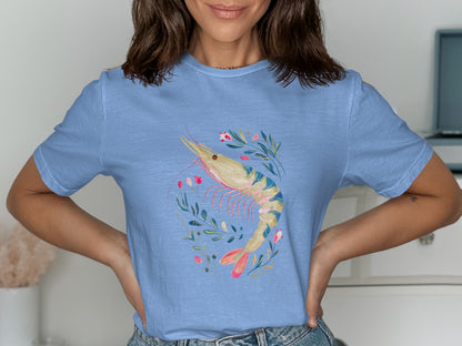 Blue t-shirt featuring a watercolor shrimp illustration with floral accents.