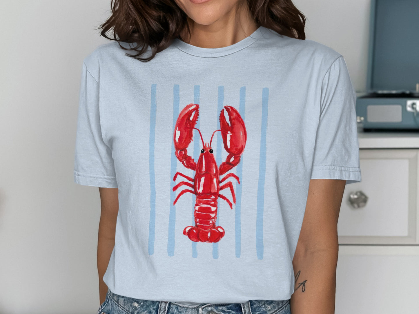 Light blue t-shirt with red lobster graphic and vertical blue stripes.