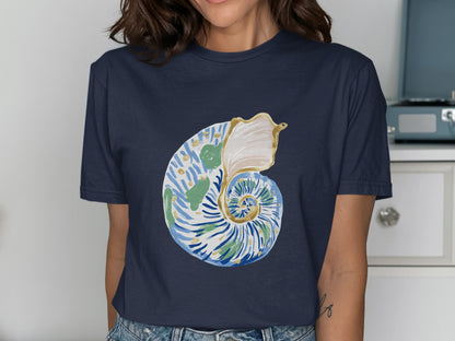 Navy t-shirt with a watercolor spiral shell design featuring green, blue, and white.