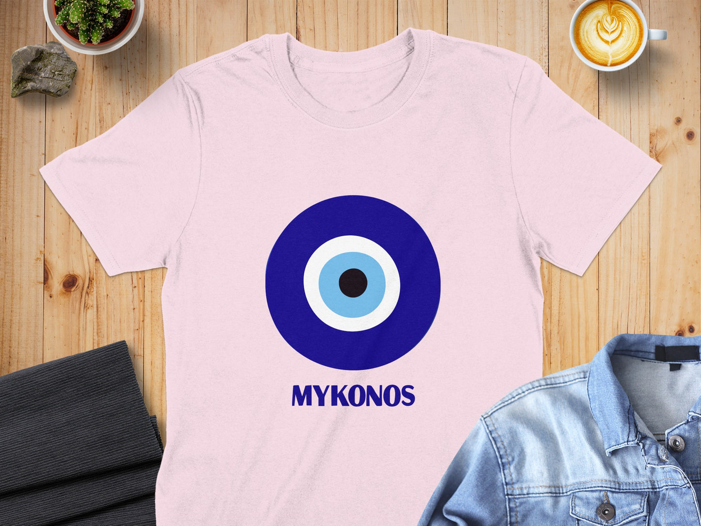 Pink t-shirt with a blue and white evil eye graphic and "MYKONOS" text.