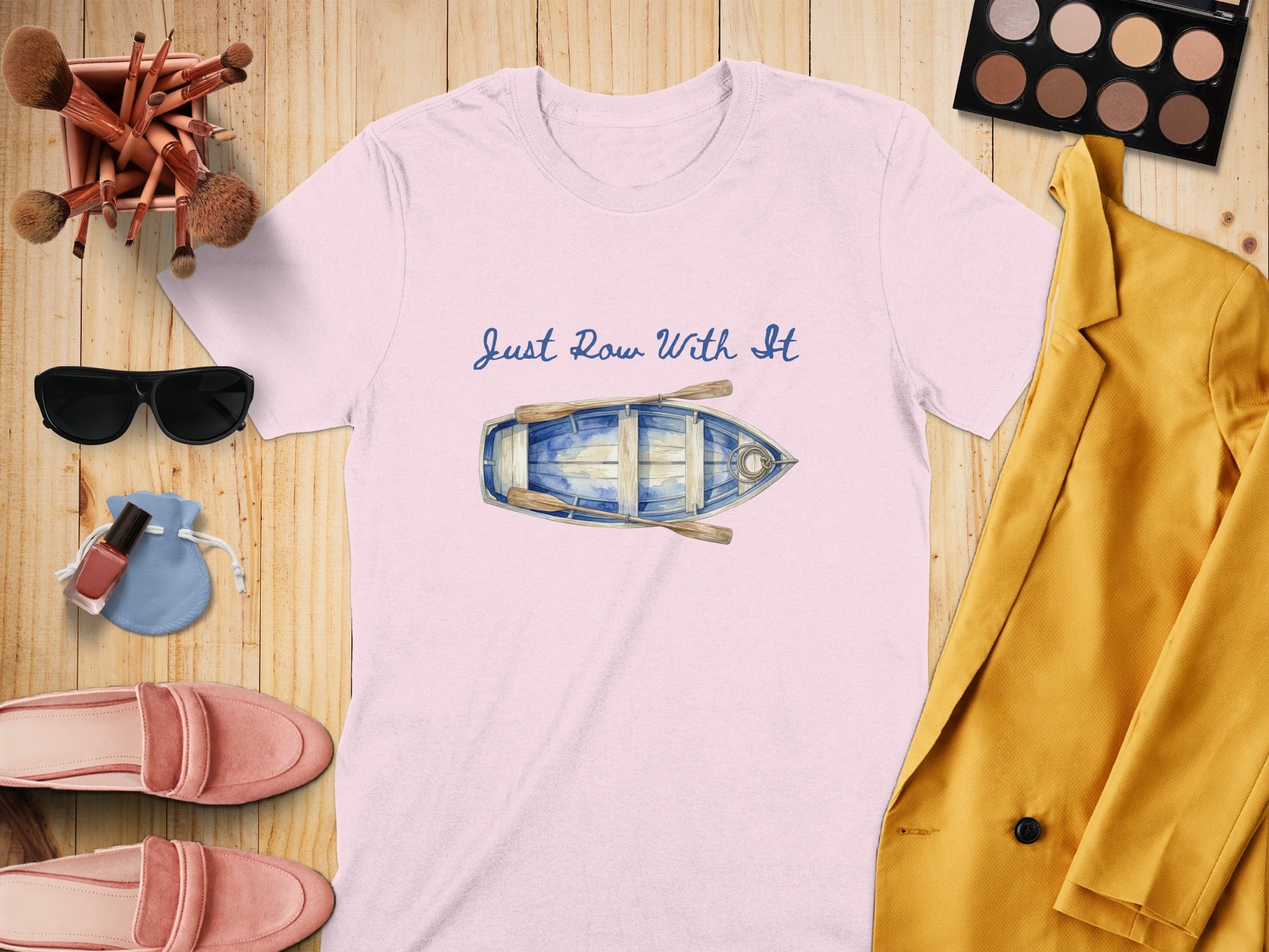 Pink t-shirt with blue rowboat graphic and text "Just Row With It".