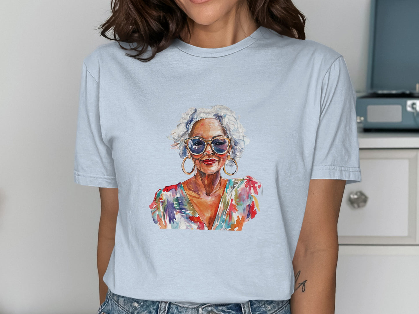 Light blue t-shirt featuring watercolor portrait of a stylish older woman.