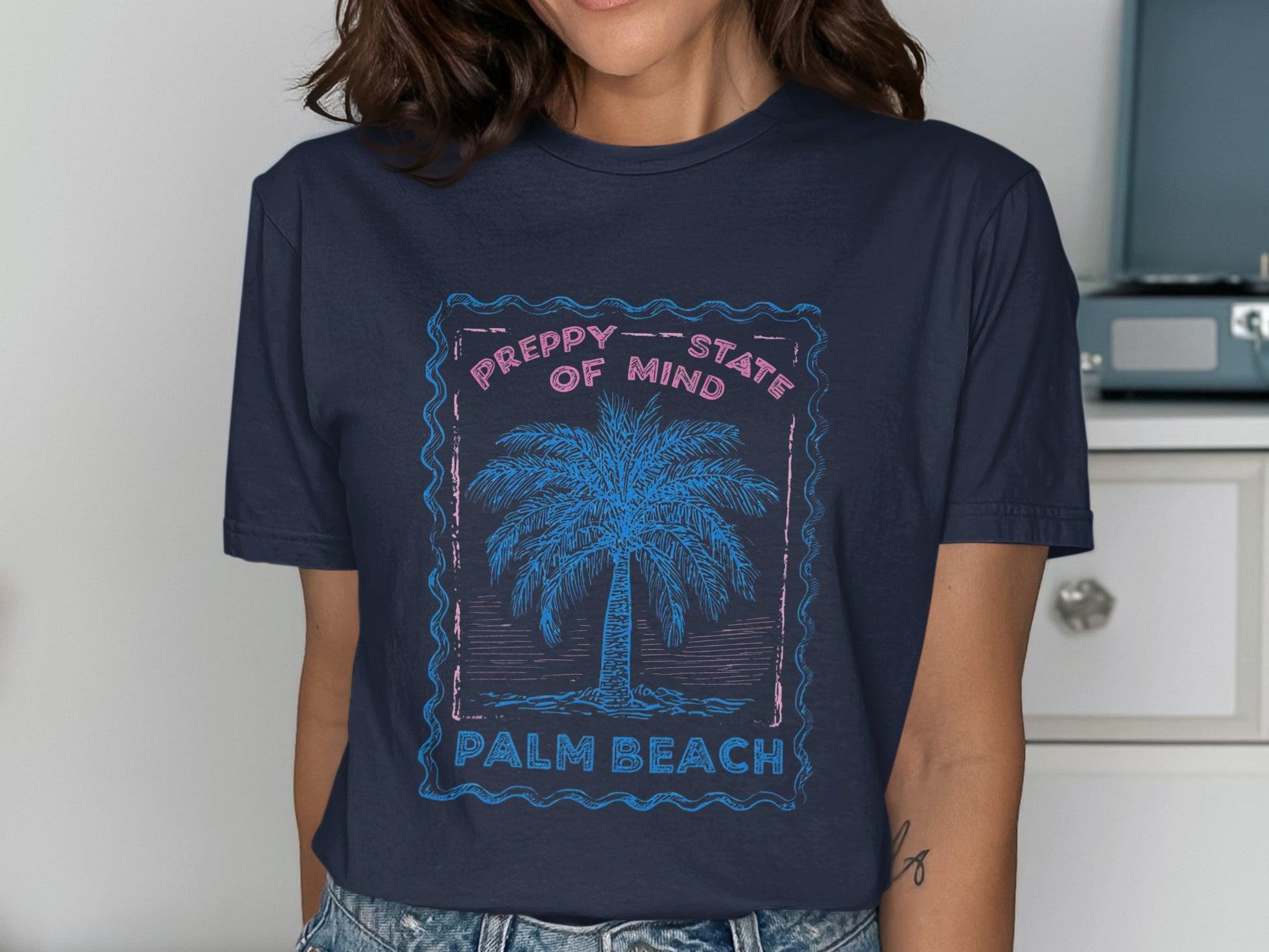 Navy t-shirt with pink frame, palm tree, and text "PREPPY STATE OF MIND PALM BEACH".