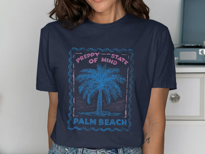 Navy t-shirt with pink frame, palm tree, and text "PREPPY STATE OF MIND PALM BEACH".