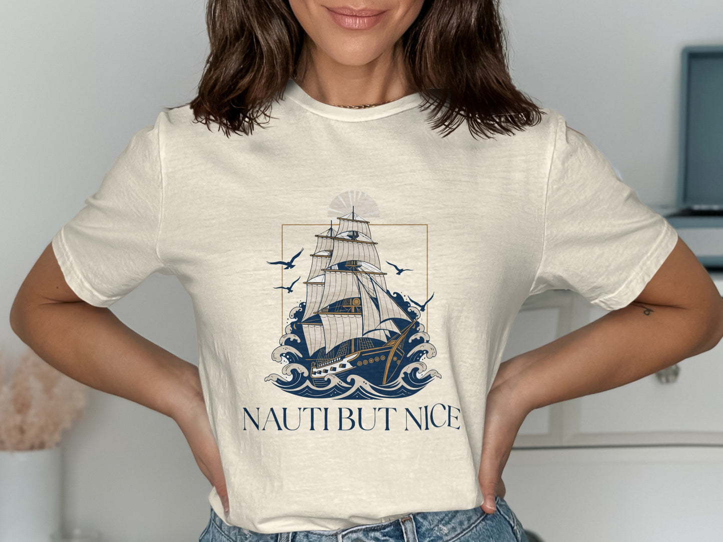 White t-shirt with a vintage sailing ship and "NAUTI BUT NICE" text.
