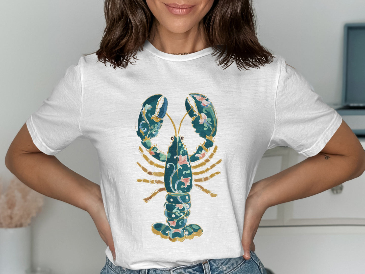 White t-shirt with a decorative blue and pink lobster graphic.