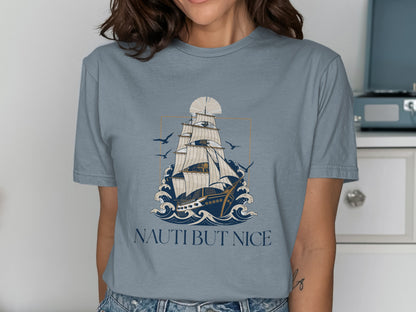 T-shirt graphic of a sailing ship on wavy water with birds and text NAUTI BUT NICE.