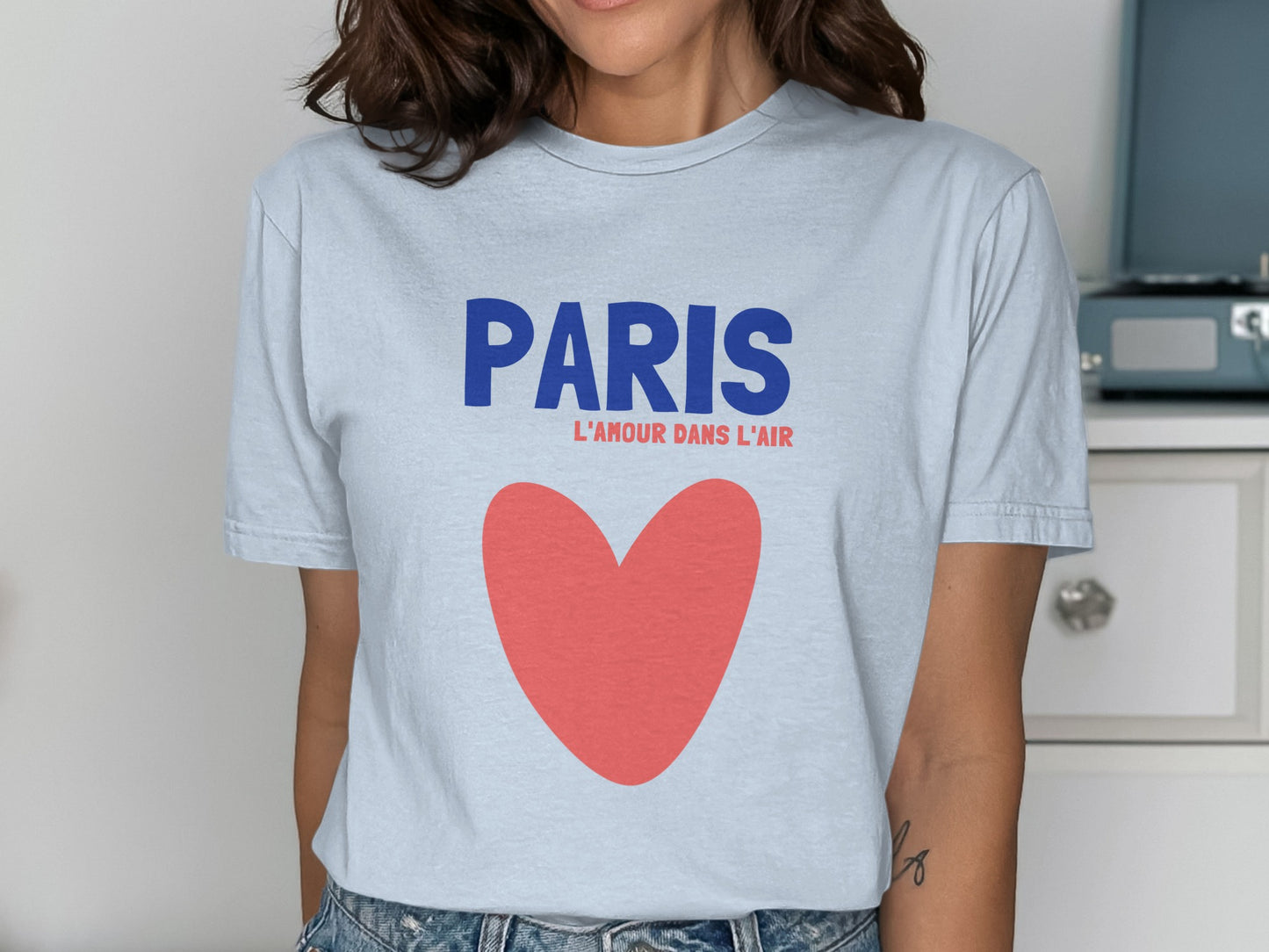 Light blue t-shirt with "PARIS L'AMOUR DANS L'AIR" and a red heart.