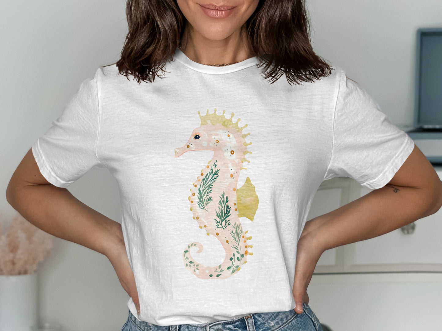 White t-shirt with a watercolor seahorse and floral design.
