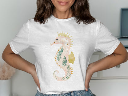 White t-shirt with a watercolor seahorse and floral design.