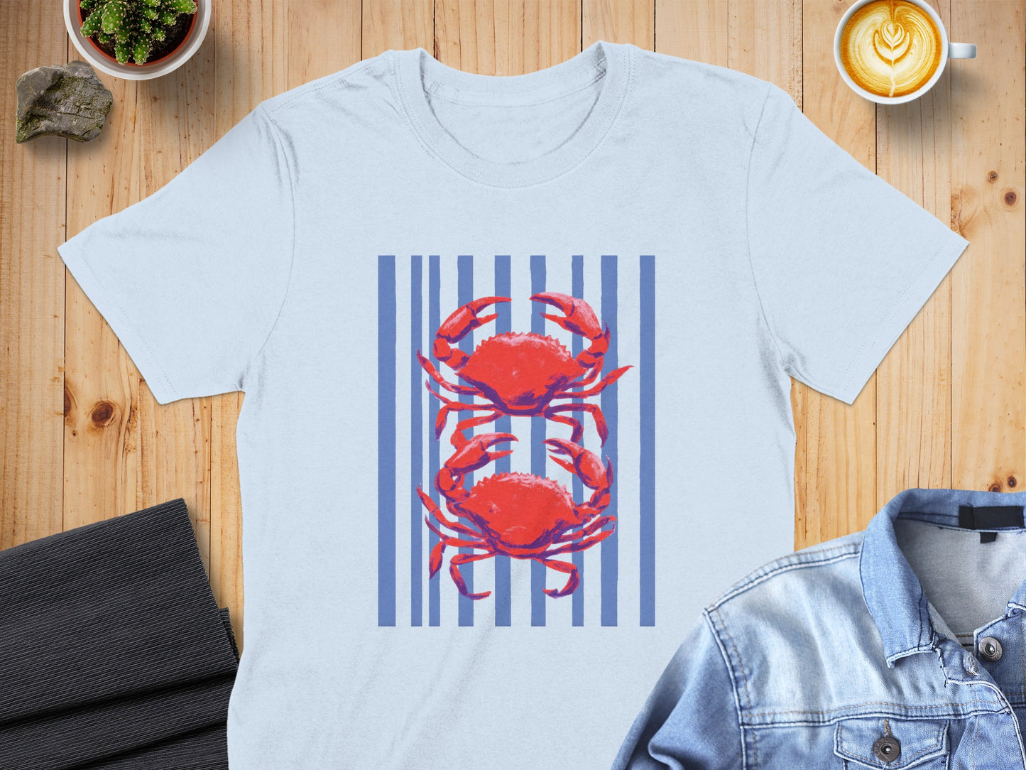 Light blue t-shirt with red crabs and blue stripes.