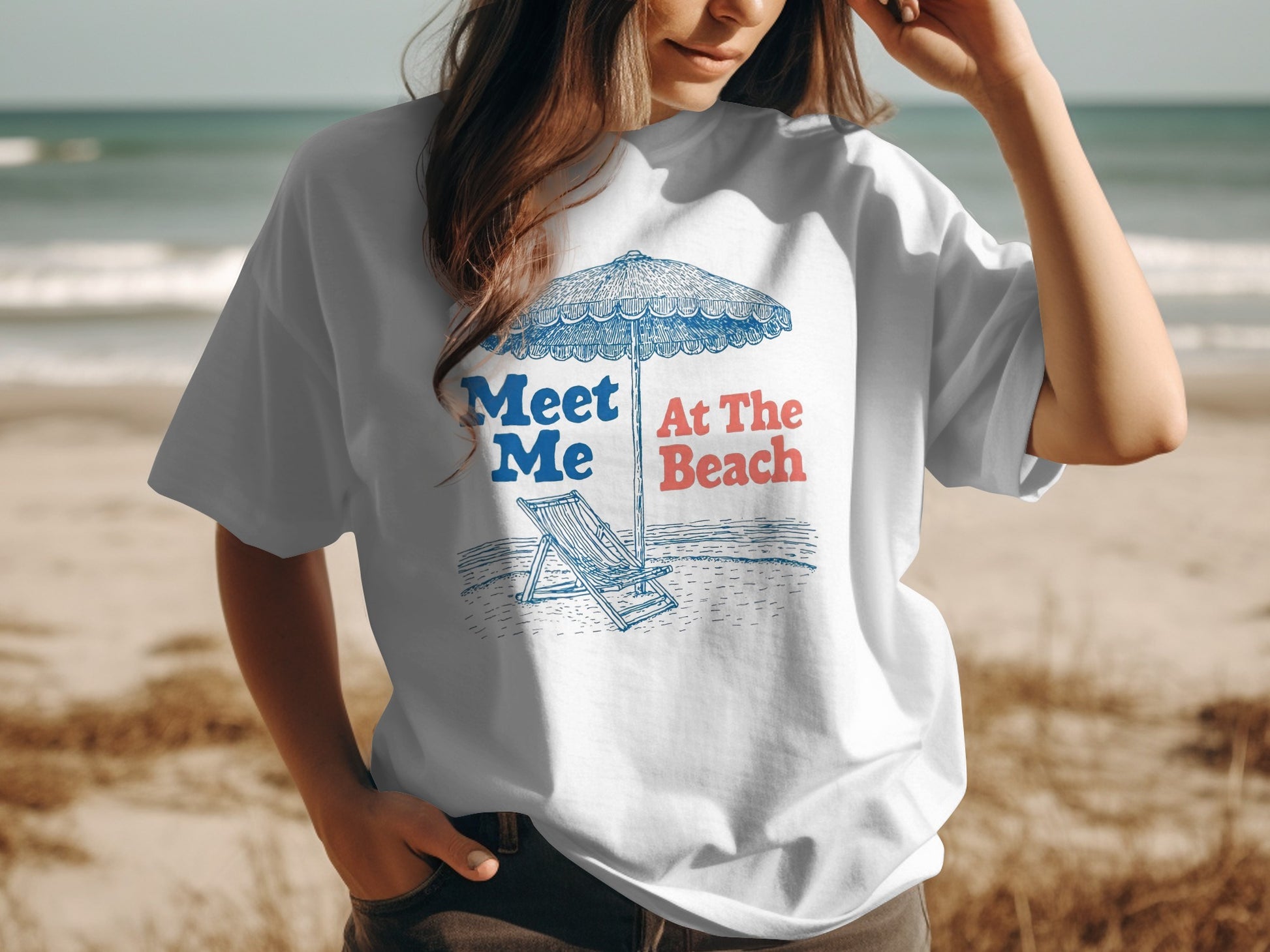 White t-shirt with "Meet Me At The Beach" and beach illustration.