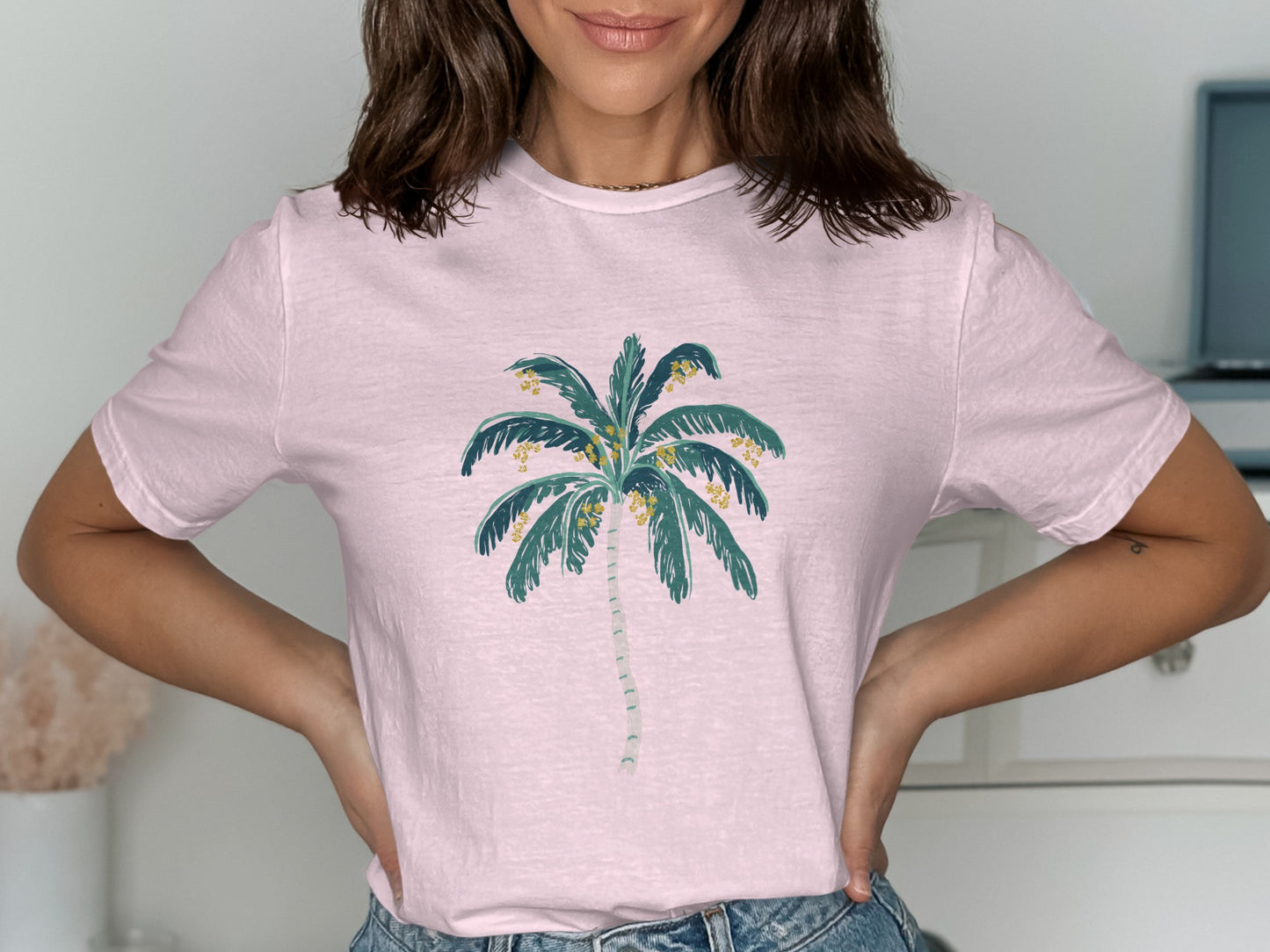 Pink t-shirt with a stylized palm tree graphic.