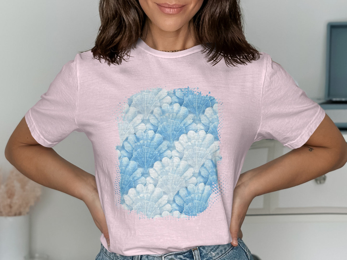 Pink t-shirt with a watercolor pattern of blue shells.