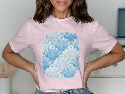 Pink t-shirt with a watercolor pattern of blue shells.