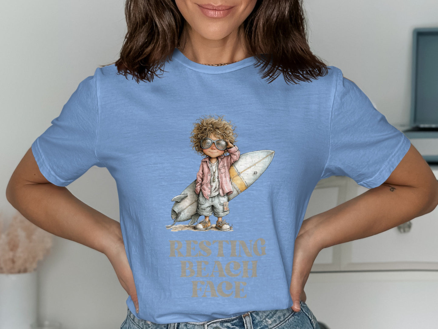 T-shirt with illustration of child with surfboard and text "RESTING BEACH FACE".