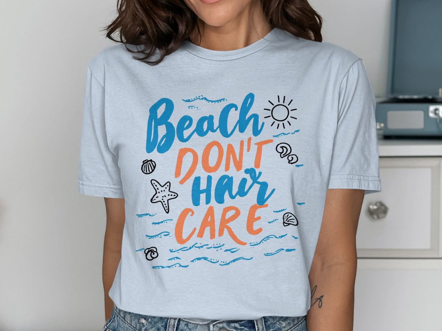 T-shirt with "Beach Don't Hair Care" text and beach-themed graphics.