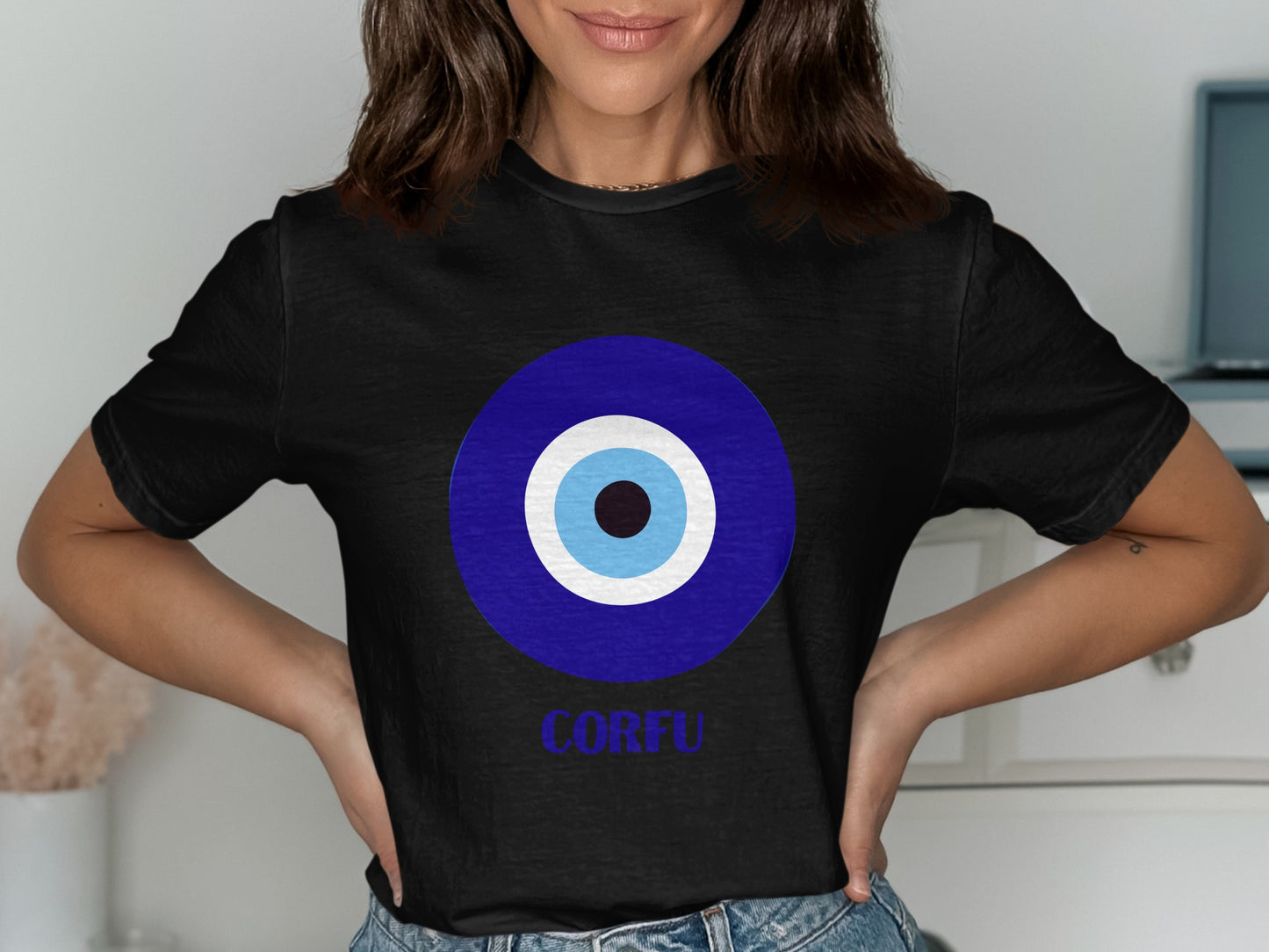 Black t-shirt with blue and white evil eye graphic and "CORFU" text.