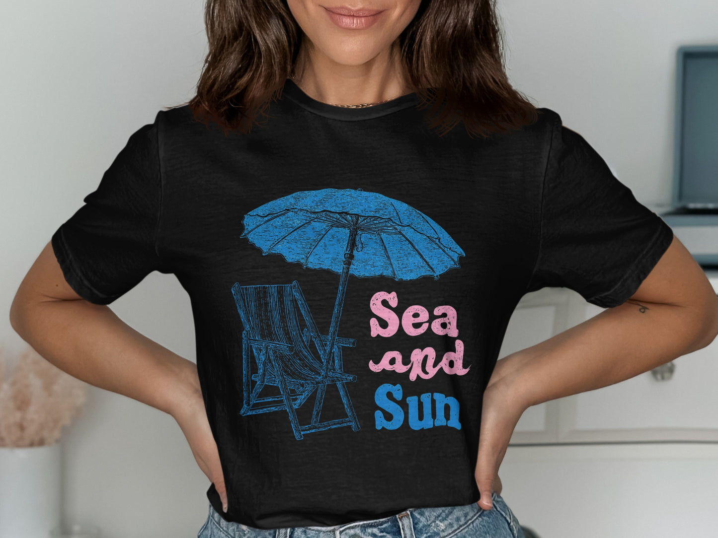 Black t-shirt with a beach chair, umbrella, and "Sea and Sun" text.