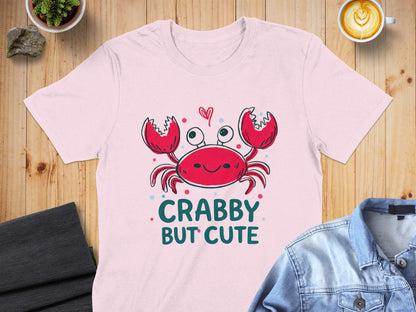 Pink t-shirt with a smiling red crab and "Crabby But Cute" text.