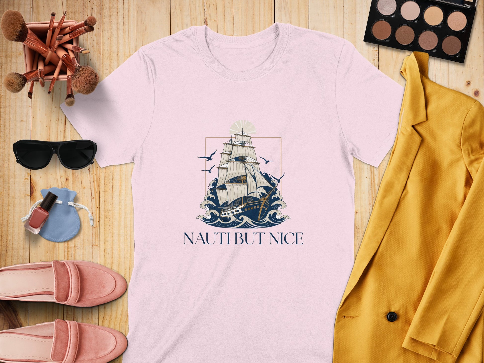 White t-shirt with sailing ship graphic and "Nauti But Nice" text.