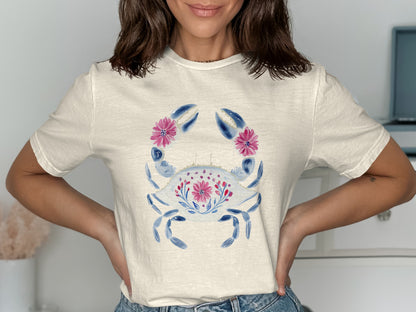 White t-shirt with a blue crab and pink floral design.