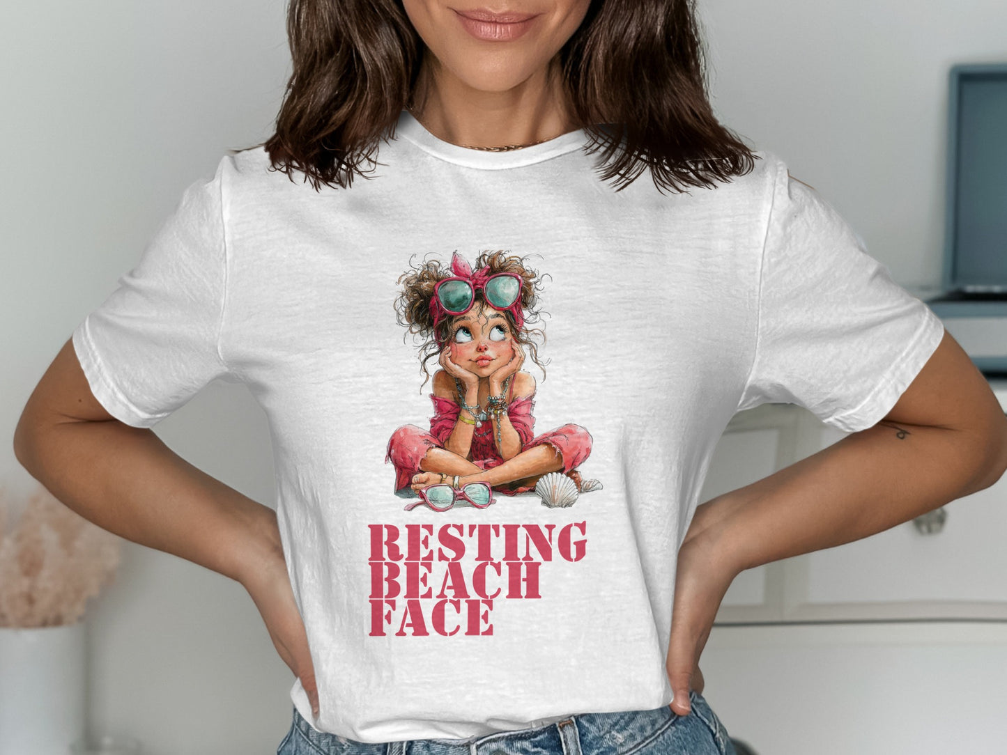 Woman wearing white t-shirt with "Resting Beach Face" graphic and seashell.