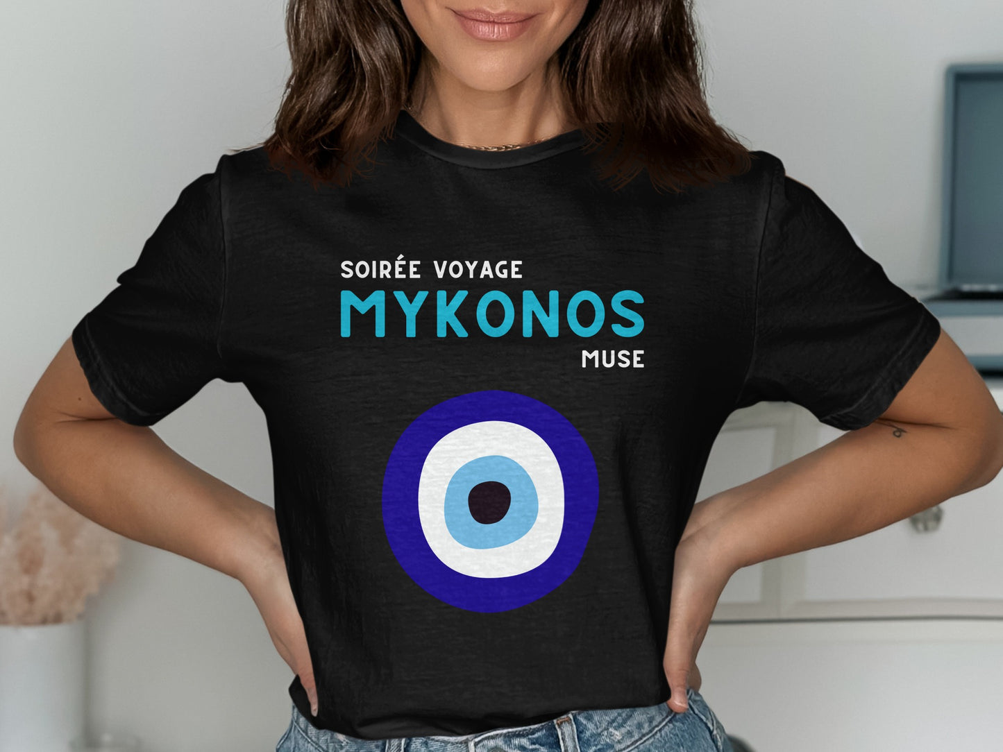 Black t-shirt with "Soirée Voyage Mykonos Muse" and a blue and white evil eye.